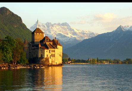 A castle with the Swiss Alps in the background, near Geneva