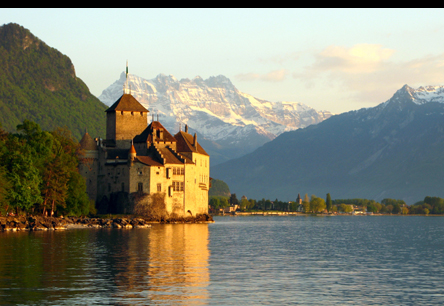 a castle with the Swiss apls in the background, near Geneva